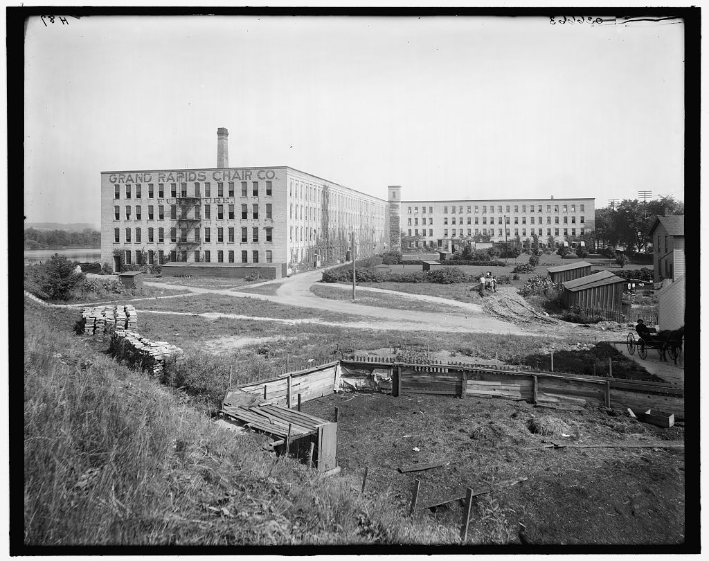 The Grand Rapids Chair Company factory, its name painted across a four-storey brick building beside a smokestack, photographed between 1905 and 1920